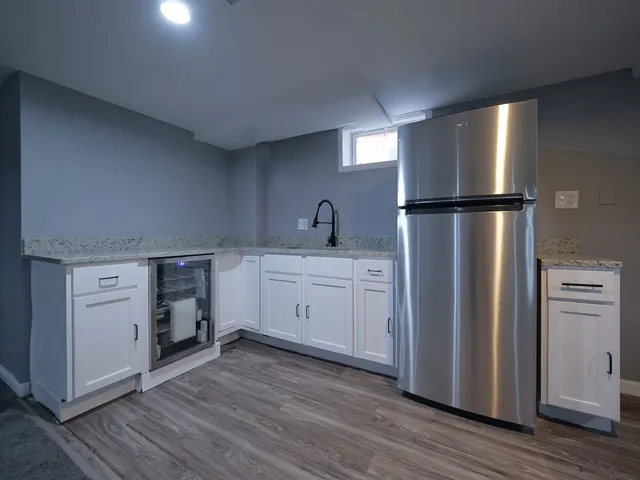 a kitchen with a refrigerator sink and cabinets