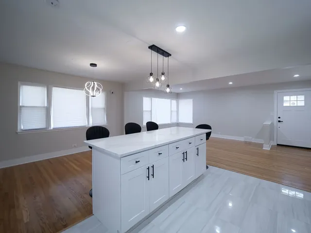 a large kitchen with lots of counter space and wooden floor