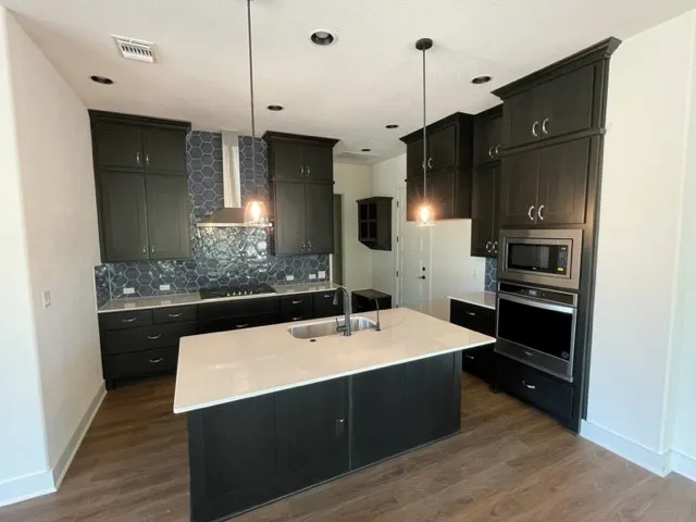 a kitchen with stainless steel appliances a sink stove and refrigerator