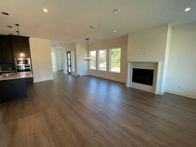 an empty room with wooden floor a fireplace and windows