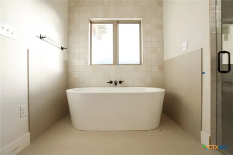 a white bath tub sitting in a bathroom next to a window