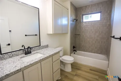 a bathroom with a granite countertop sink toilet and shower