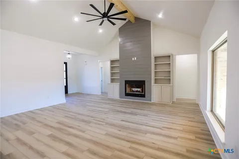 a view of empty room with wooden floor and fireplace
