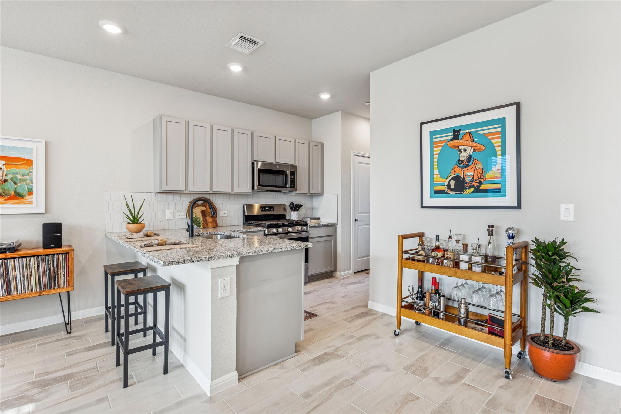 9015 Cattle Baron Path, Unit 1002 Austin, TX 78747 - Photo 8 of 20 a kitchen with stainless steel appliances kitchen island granite countertop a refrigerator and a stove top oven