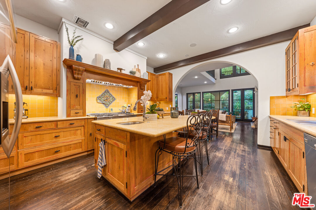 3606 Mandeville Canyon Road Los Angeles, CA 90049 - Photo 11 of 32 a kitchen with a stove a refrigerator and wooden cabinets