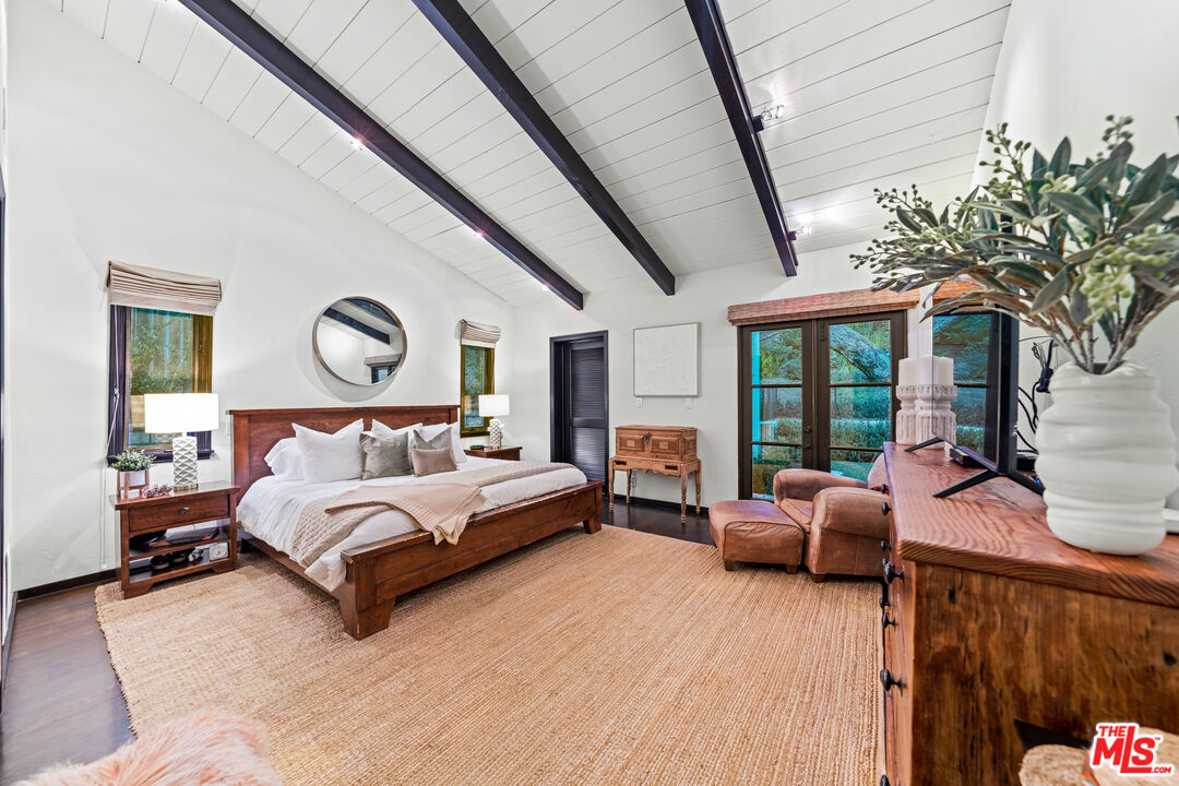 3606 Mandeville Canyon Road Los Angeles, CA 90049 - Photo 17 of 32 a spacious bedroom with a bed couch and a large window