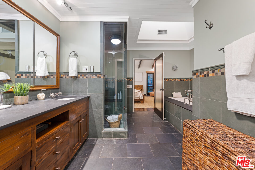 3606 Mandeville Canyon Road Los Angeles, CA 90049 - Photo 19 of 32 a spacious bathroom with a double vanity sink and a mirror