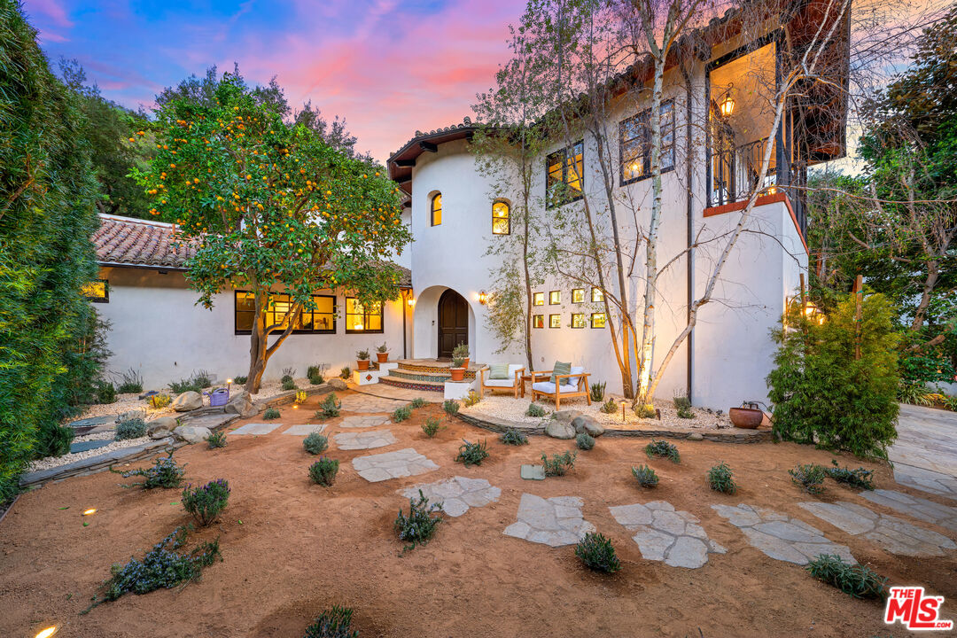 3606 Mandeville Canyon Road Los Angeles, CA 90049 - Photo 2 of 32 a backyard of a house with table and chairs