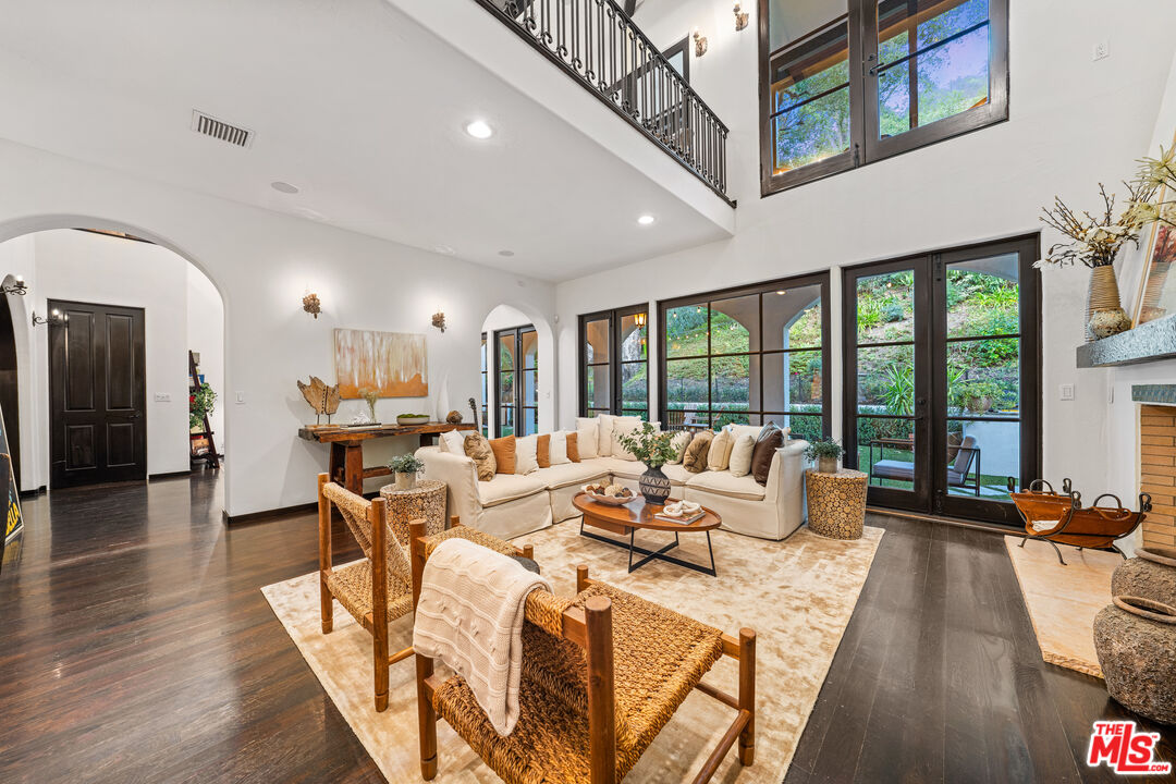 3606 Mandeville Canyon Road Los Angeles, CA 90049 - Photo 5 of 32 a living room with furniture large windows and wooden floor