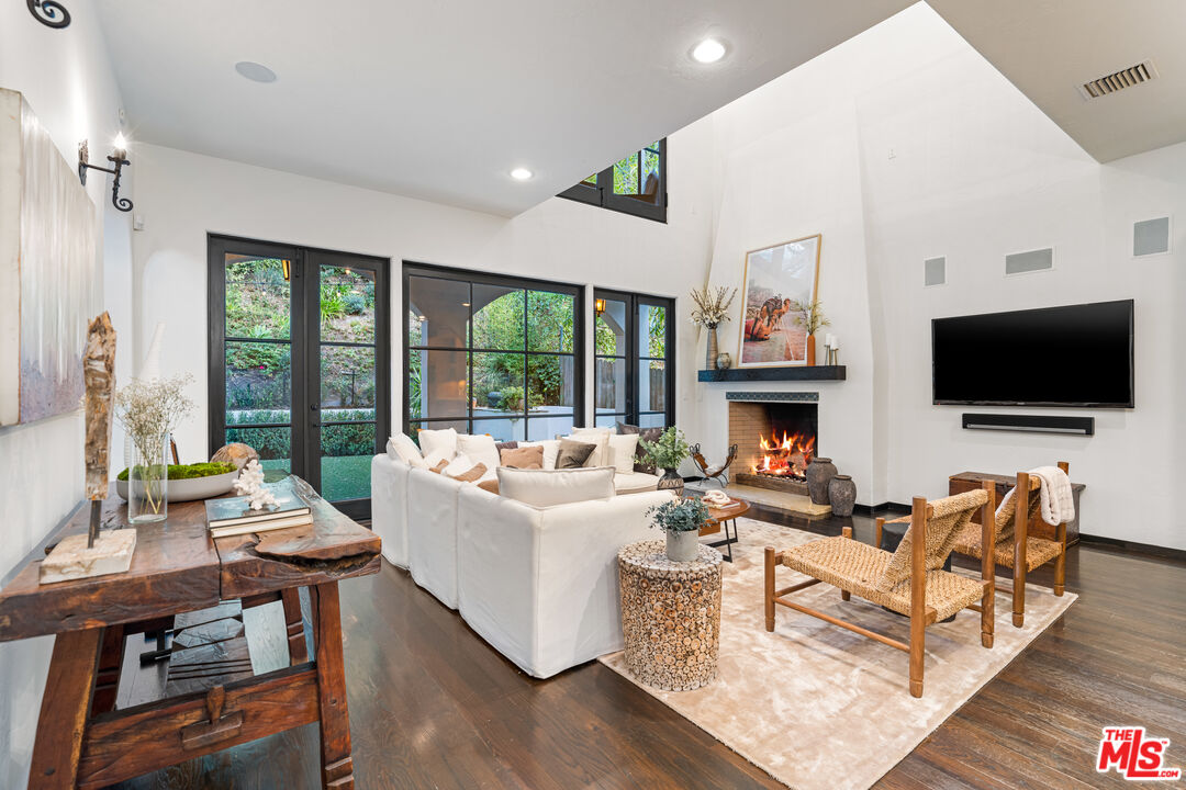 3606 Mandeville Canyon Road Los Angeles, CA 90049 - Photo 7 of 32 a living room with fireplace furniture and a flat screen tv