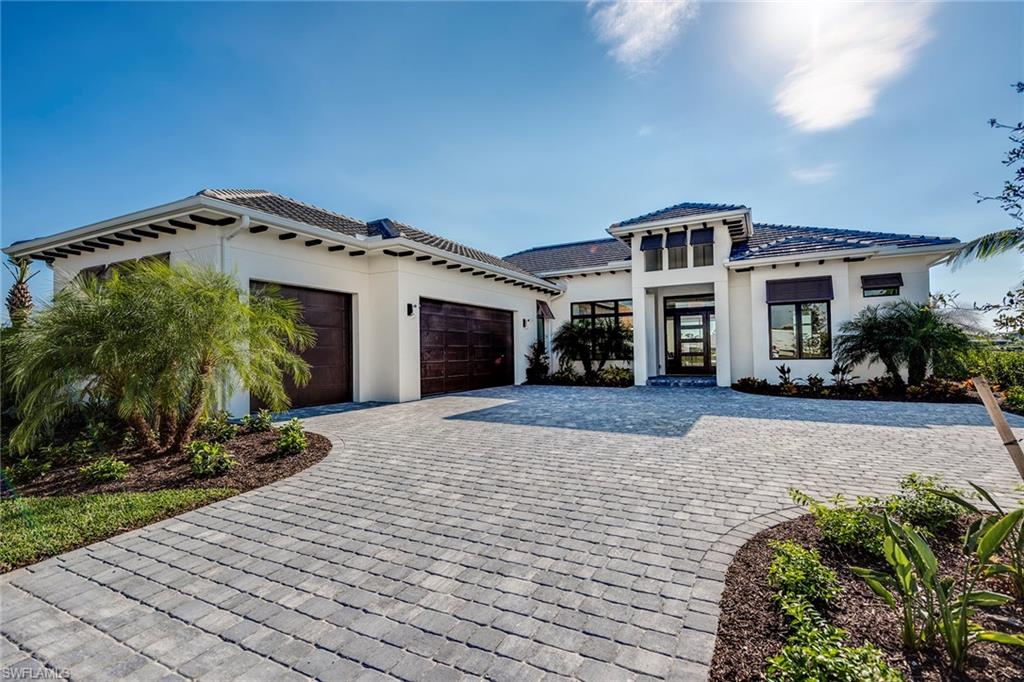 9828 Montiano Place Naples, FL 34113 - Photo 1 of 30 a front view of a house with a yard and potted plants