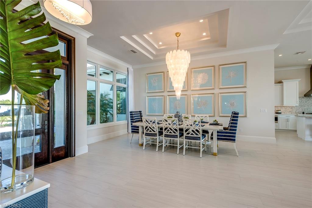9828 Montiano Place Naples, FL 34113 - Photo 13 of 30 a dining room with furniture and a floor to ceiling window