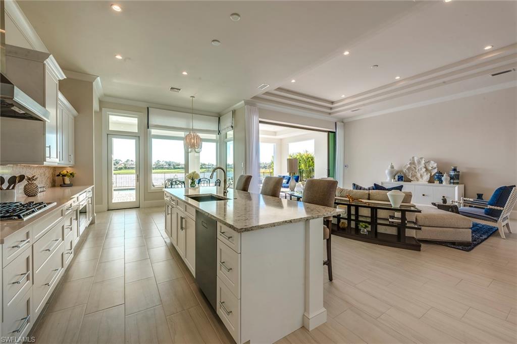 9828 Montiano Place Naples, FL 34113 - Photo 17 of 30 a large kitchen with kitchen island lots of counter space a sink a window and stainless steel appliances