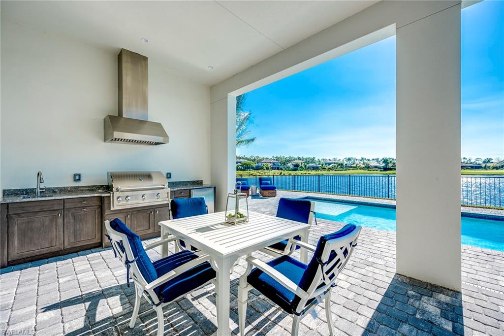 9828 Montiano Place Naples, FL 34113 - Photo 19 of 30 a living room with a table chairs and a kitchen view