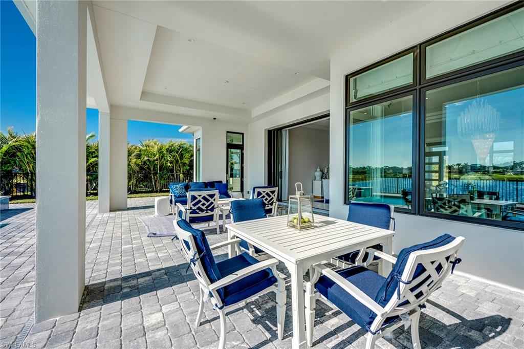 9828 Montiano Place Naples, FL 34113 - Photo 20 of 30 a view of a patio with a dining table and chairs