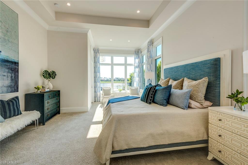 9828 Montiano Place Naples, FL 34113 - Photo 22 of 30 a large bedroom with a bed and wooden floor