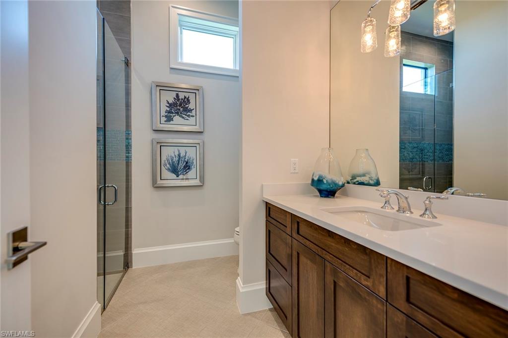 9828 Montiano Place Naples, FL 34113 - Photo 28 of 30 a bathroom with a sink and a mirror