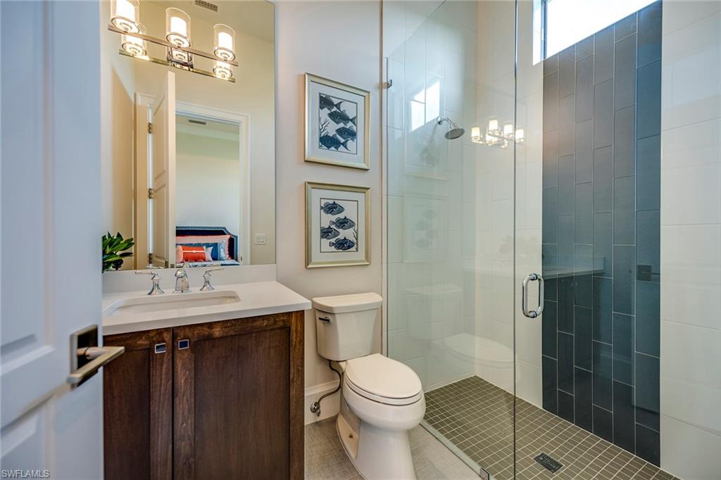 9828 Montiano Place Naples, FL 34113 - Photo 30 of 30 a bathroom with a sink a toilet a mirror and shower