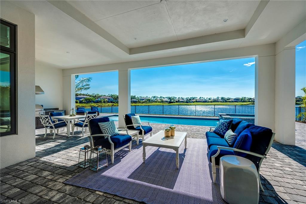 9828 Montiano Place Naples, FL 34113 - Photo 6 of 30 a living room with furniture and a floor to ceiling window
