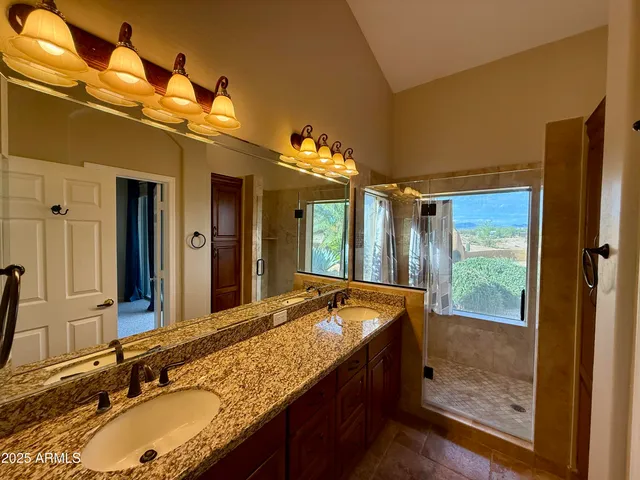 a bathroom with a granite countertop sink mirror and shower