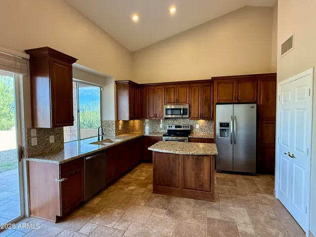 a kitchen with stainless steel appliances a refrigerator and a stove top oven