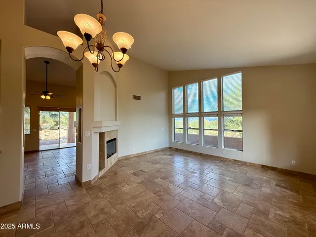 a view of a livingroom with a chandelier fan and a fireplace