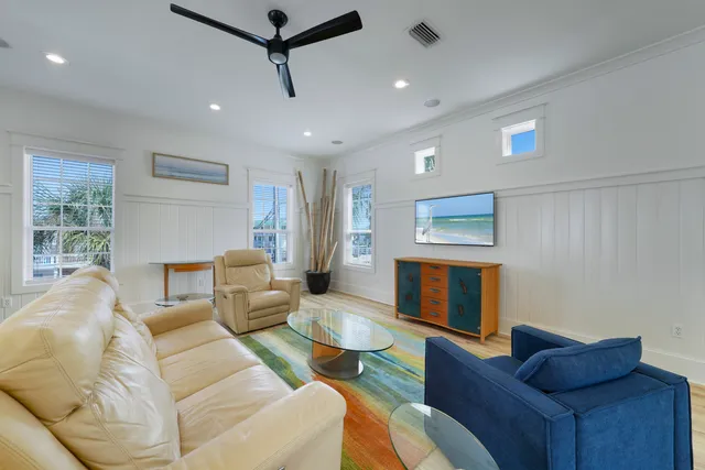 a living room with stainless steel appliances kitchen island granite countertop furniture a rug kitchen view and a chandelier