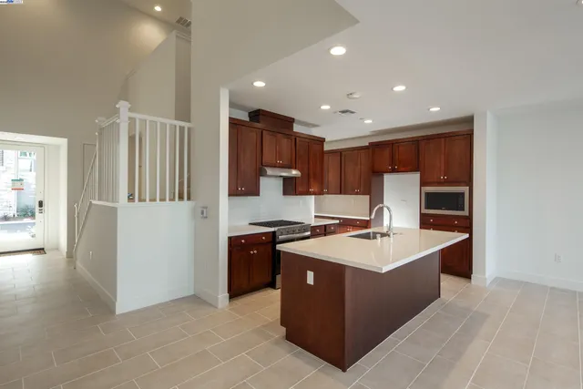 a kitchen with stainless steel appliances granite countertop a stove a refrigerator and a sink