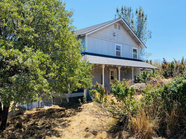 a view of a house with a yard and potted plants