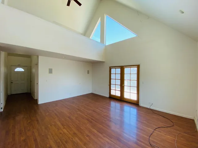 an empty room with wooden floor and entryway