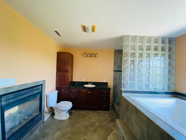 a bathroom with a toilet mirror vanity and a shower