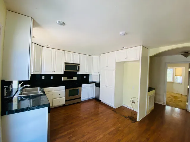 a kitchen with stainless steel appliances a refrigerator and a stove top oven