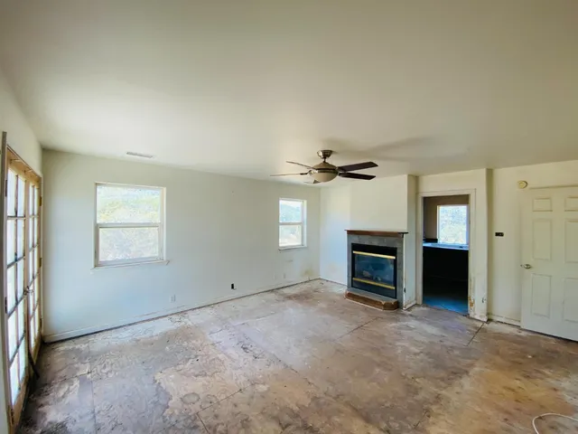 an empty room with fireplace and windows