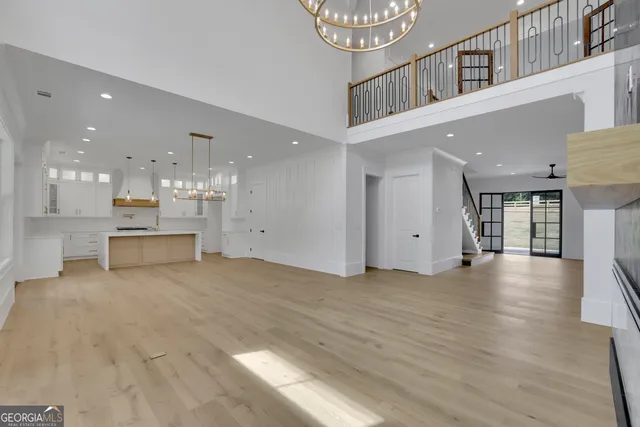 a large kitchen with granite countertop a large counter top a sink stainless steel appliances and cabinets