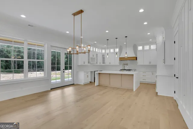 a view of a kitchen with kitchen island a sink stainless steel appliances and cabinets