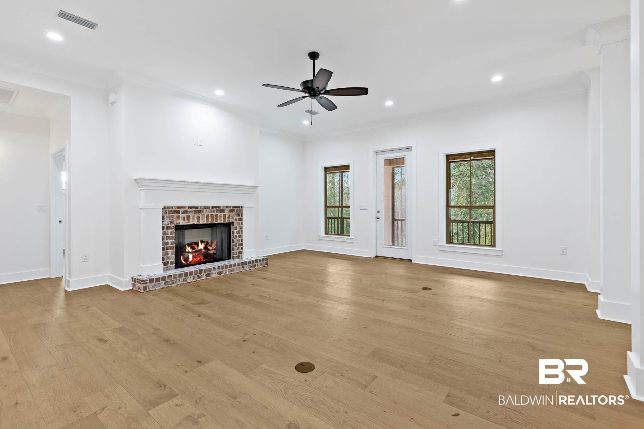 6656 Garrison Drive Daphne, AL 36527 - Photo 22 of 57 Unfurnished living room featuring light wood finished floors, a brick fireplace, crown molding, recessed lighting, and a ceiling fan