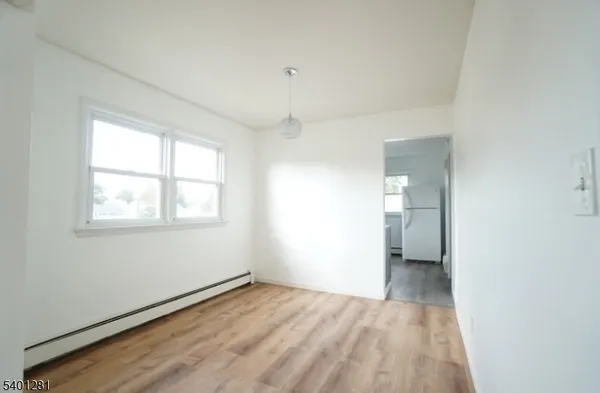 a view of a room with wooden floor and window