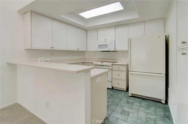 a utility room with cabinets washer and dryer