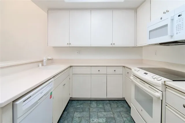 a kitchen with white cabinets and white appliances