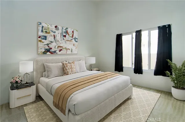 a bedroom with a large bed and a potted plant