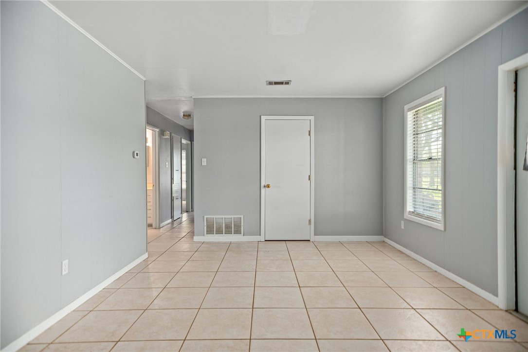 525 Travis Street Port Lavaca, TX 77979 - Photo 11 of 24 a view of an empty room with window and chandelier fan
