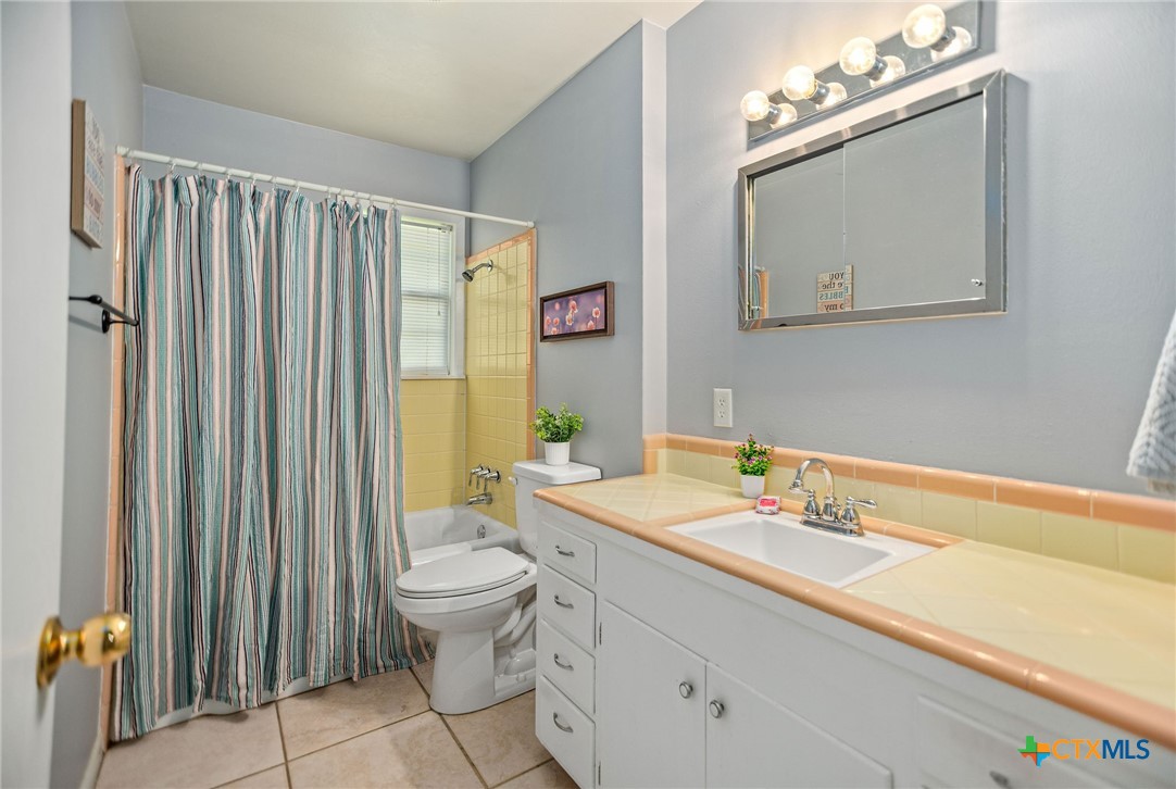 525 Travis Street Port Lavaca, TX 77979 - Photo 15 of 24 a bathroom with a sink a toilet and mirror