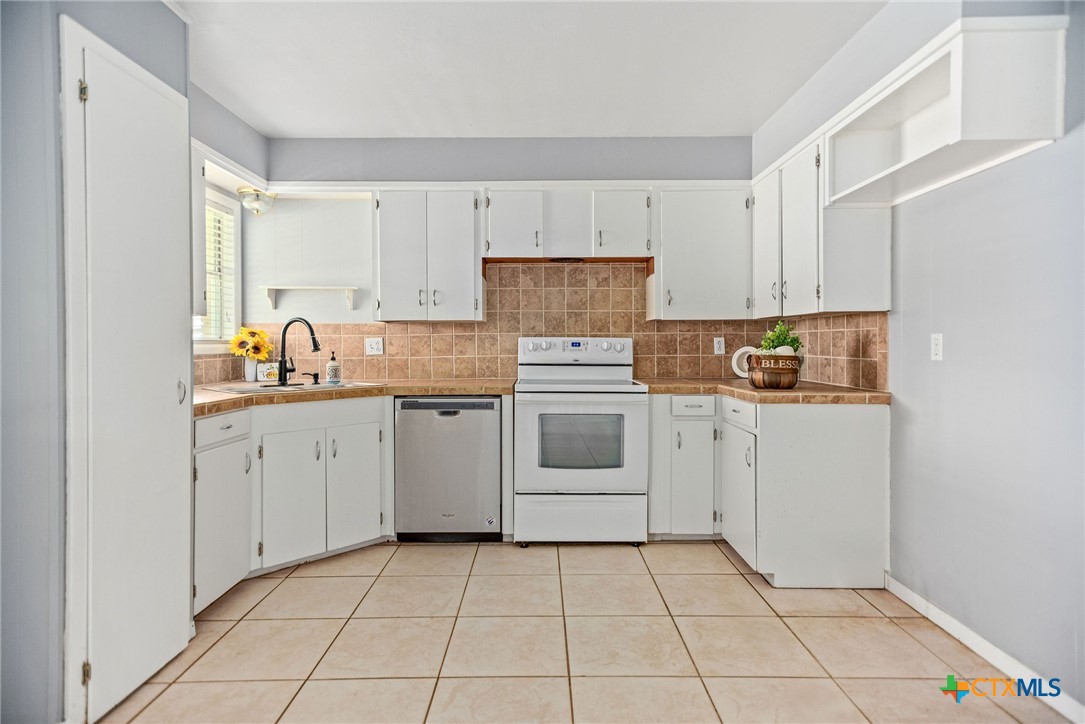 525 Travis Street Port Lavaca, TX 77979 - Photo 7 of 24 a kitchen with cabinets appliances and a window