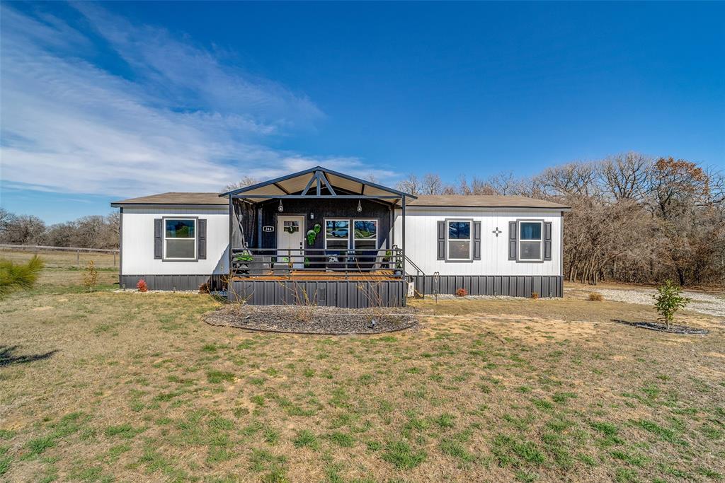 344 Hometown Way Springtown, TX 76082 - Photo 2 of 13 a front view of a house with a yard