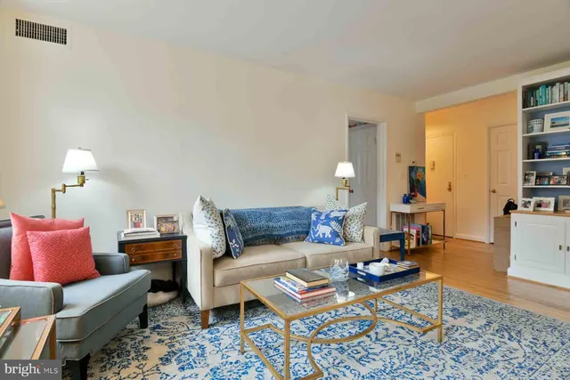 a living room with furniture a rug and a bookshelf