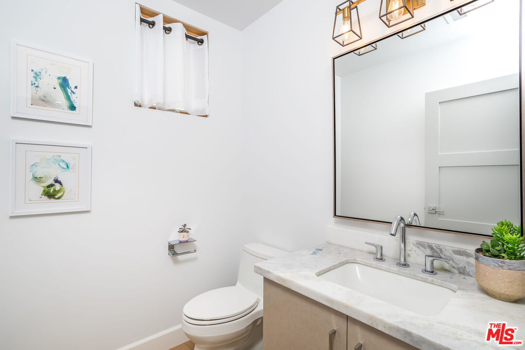 4531 Tujunga Avenue Studio City, CA 91602 - Photo 26 of 49 a bathroom with a granite countertop sink a toilet and a mirror