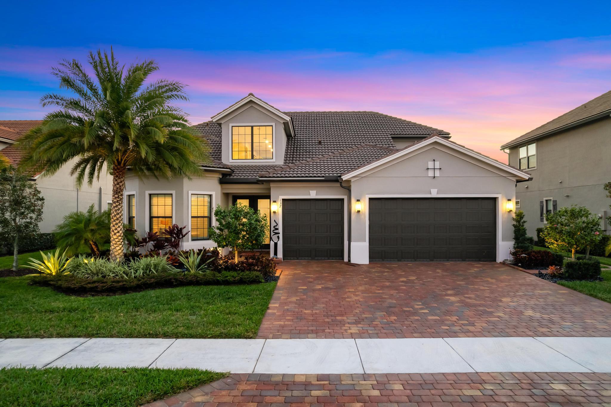 137 Cinder Dunes Point Jupiter, FL 33478 - Photo 1 of 45 a front view of a house with a garden and yard