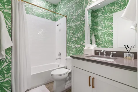 a bathroom with a granite countertop sink a toilet and a large mirror