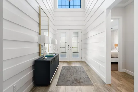 a hallway view with wooden floor and electronic appliances