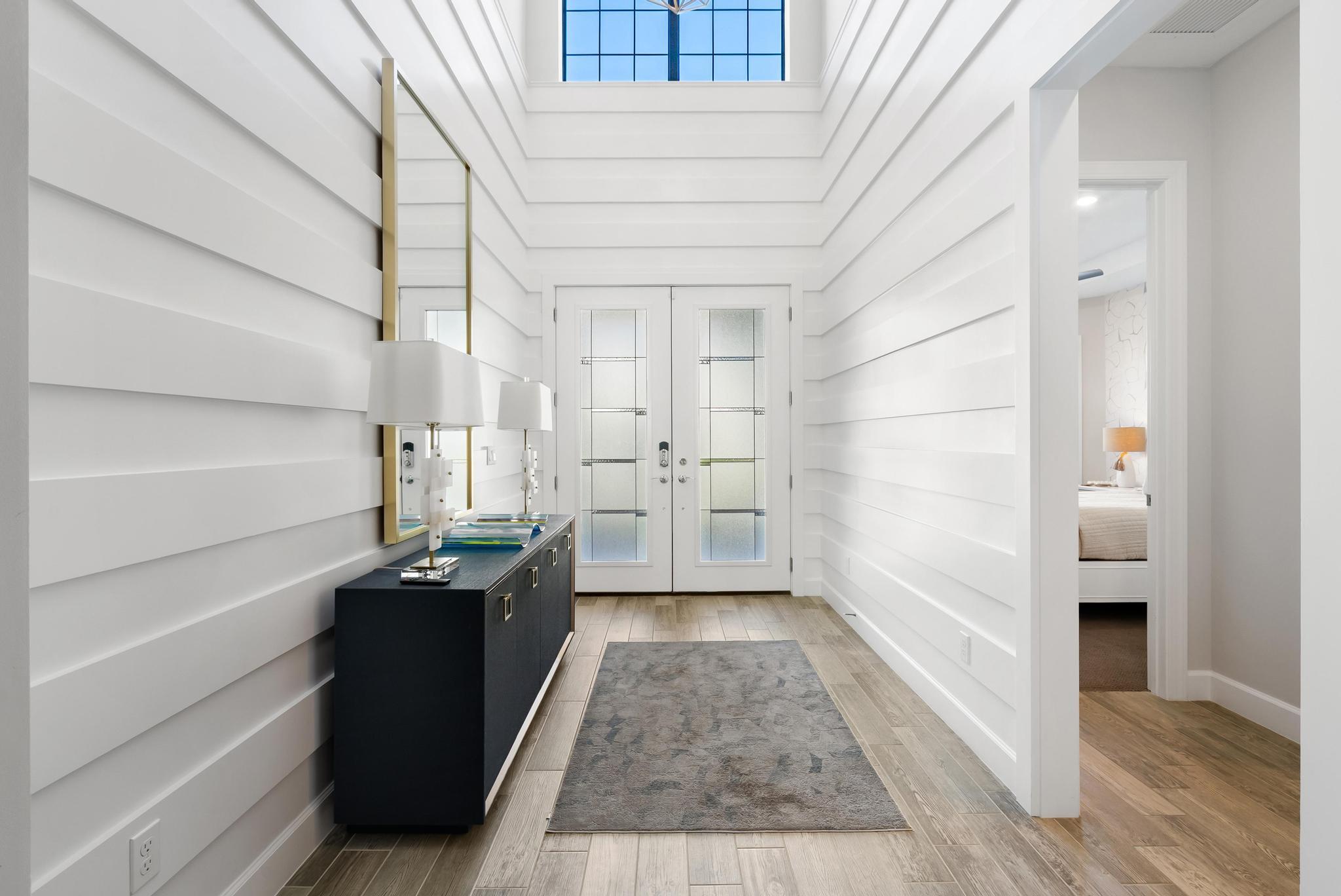 137 Cinder Dunes Point Jupiter, FL 33478 - Photo 2 of 45 a hallway view with wooden floor and electronic appliances
